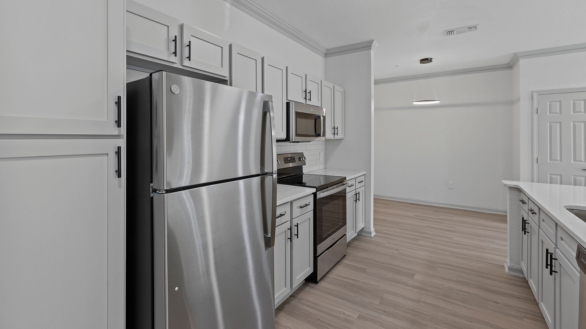 Renovated Kitchen with Quartz Countertops, black hardware, and stainless steel appliances.